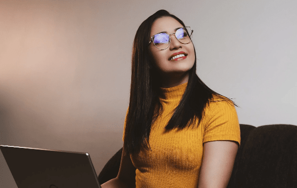 Woman in yellow turtleneck smiling and looking up, representing Help4Access technical consultants.