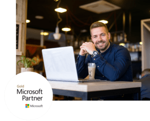 Smiling man with laptop at cafe, representing Help4Access Microsoft Access support services.